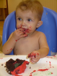 baby eating first birthday cake